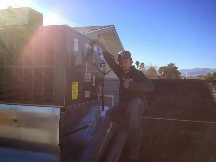 HVAC technician performing Air Duct Repair on a rooftop unit in North Decatur
